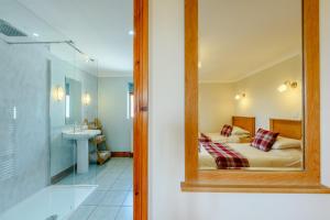 a bedroom with a bed and a bathroom with a mirror at Beudy Bach in Silian +66 photos