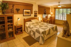 a bedroom with a bed with a cheetah on the floor at Tree Lodge by My Adventure House in Marloth Park