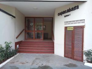 une entrée d'un bâtiment avec une porte rouge dans l'établissement Centro de Búzios 2 quartos, à Búzios