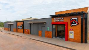 un edificio con una porta rossa su una strada di Flat & Hotel Executive a Confresa