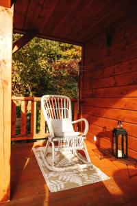 ストロニエ・シロンスキエにあるChatka mojego dziadkaの小屋のポーチに置かれた白いロッキングチェア