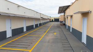 an empty hallway of a building with a yellow line on it at Flat & Hotel Executive in Confresa