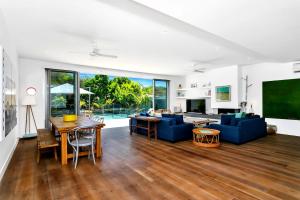 Una sala de estar con un sofá azul y una mesa. en Stonecutters 2, en Byron Bay