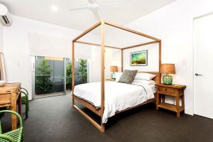 1 dormitorio con cama con dosel y mesa en Stonecutters 2, en Byron Bay 17 fotos más