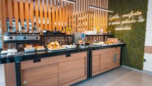 una fila di buffet in un ristorante con cibo in esposizione di Flat & Hotel Executive a Confresa
