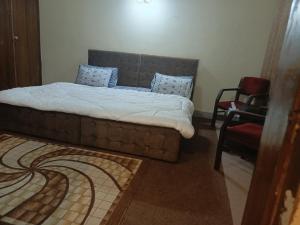 een slaapkamer met een bed en een stoel bij The Residency in Islamabad