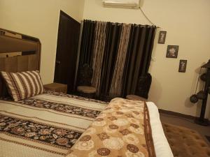 een slaapkamer met een bed en een raam met zwarte gordijnen bij The Residency in Islamabad