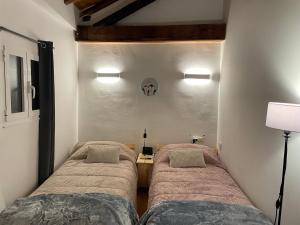 a bedroom with two beds and a table with a lamp at Casa do Terrado in Tourém