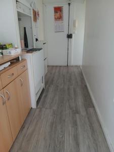 a kitchen with white cabinets and a wooden floor at Chambre simple proche de mairie Orly in Orly +3 photos