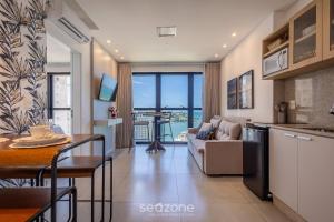 イタペマにあるMHF II - Apts Variados em Prédio com Vista para o Mar em Itapemaのソファとテーブルのあるキッチンとリビングルーム