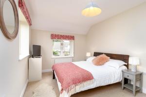 a bedroom with a bed with a red blanket and a window at Poachers Lodge At Tapnell Farm in Yarmouth +17 photos