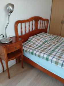 a bed with a nightstand and a lamp on a table at Chambre simple proche de mairie Orly in Orly