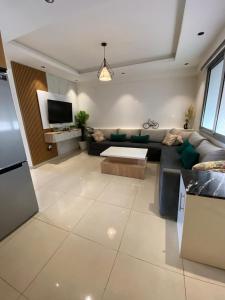 ein Wohnzimmer mit Sofa und Fernseher in der Unterkunft Banana Village Surf Apartment in Aourir