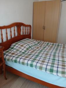 a bedroom with a bed with a plaid blanket at Chambre simple proche de mairie Orly in Orly