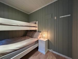 オイヤーにあるHafjell Ski-in Ski-Outのベッドルーム1室(二段ベッド1組、ナイトスタンド、ランプ付)