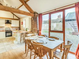 eine Küche und ein Esszimmer mit Tisch und Stühlen in der Unterkunft The Forge - Uk37519 in Routh