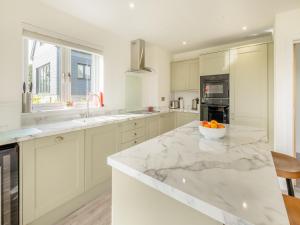 een keuken met witte kasten en een kom sinaasappels op een aanrecht bij Viking - Uk44983 in Newport