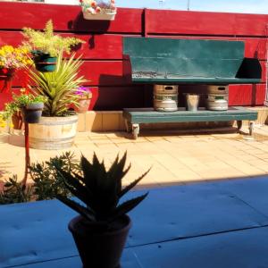 a bench with potted plants in front of a red wall at Casa Davalillo in San Asensio