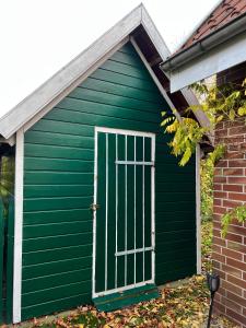 un cobertizo verde con una puerta en un lateral en Hümmling HA16, en Sögel
