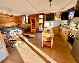 een woonkamer met een bank en een keuken bij Le Refuge d'Ours, Champagny in Champagny-en-Vanoise