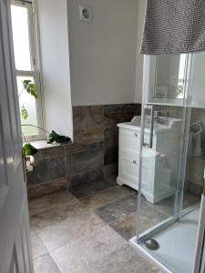 un baño con ducha y lavabo en The Farmhouse at Solsgirth Home Farm, en Dollar