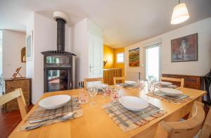 ein Esszimmer mit einem Tisch und einem Herd in der Unterkunft Maison de charme indépendante - Le Creusot in Le Creusot