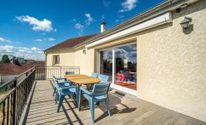 ein Holztisch und Stühle auf einer Terrasse in der Unterkunft Maison de charme indépendante - Le Creusot in Le Creusot