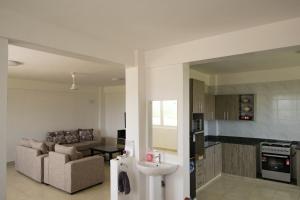 a kitchen and living room with a couch and a sink at Tsavo Zurani in Voi