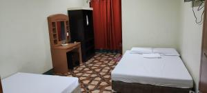 a small room with two beds and a mirror at Feel Home Suites in Pagadian
