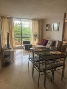 ein Wohnzimmer mit Tisch und Couch in der Unterkunft Apartamento Vacacional en Hacienda Peñalisa Ceiba Ricaurte in Ricaurte