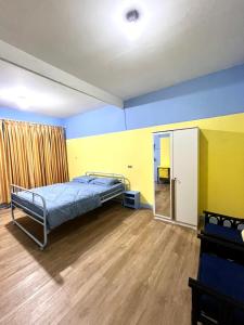 a bedroom with a bed and yellow and blue walls at Zona Bobo Yellow Cream Cheese Moslem Friendly By Belgareti in Cimareme