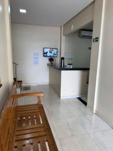 a waiting room with a bench and a tv on the wall at Brasil hotel in Canaã dos Carajás