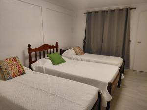 a room with three beds and a green pillow at La Casa de Mirna II in Formosa