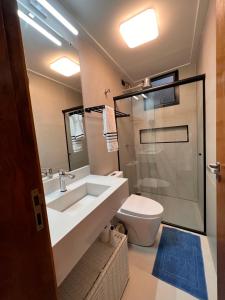 ein Badezimmer mit Waschbecken und Toilette in der Unterkunft CasadevidroTTP Pé na areia in São Sebastião + 19 Fotos