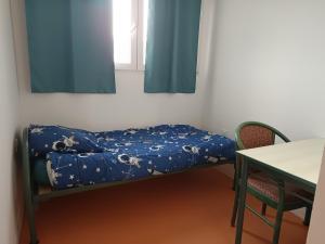 Cama en habitación con ventana y mesa en Arkenciel, en Mudaison