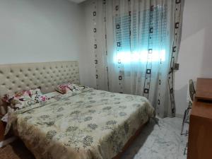 a bedroom with a bed and a window with curtains at Port la goulette in La Goulette
