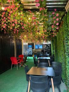 a restaurant with tables and chairs and pink flowers at Newcamp Hotel and Apartments in Abuja