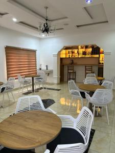 een restaurant met houten tafels en witte stoelen bij Newcamp Hotel and Apartments in Abuja