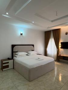 a bedroom with a large bed in a room at Newcamp Hotel and Apartments in Abuja