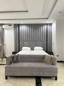 a bedroom with a bed and a couch in a room at Newcamp Hotel and Apartments in Abuja