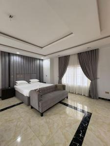 a large bedroom with a bed and a couch at Newcamp Hotel and Apartments in Abuja