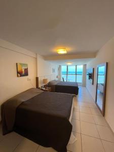Una habitación de hotel con dos camas y vista al mar. en Beach Class Executive por Yolo, en Recife
