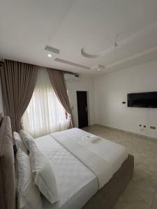 阿布贾Newcamp Hotel and Apartments的卧室里有一张白色的大床和一扇窗户