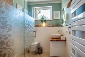 a bathroom with a toilet and a sink and a window at Villa Gute Zeit - Cosy Apartment in Nortorf +11 photos