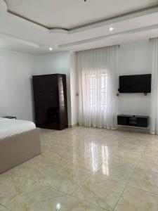 阿布贾Newcamp Hotel and Apartments的一间卧室，里面有一张床和一台平板电视 更多24张照片