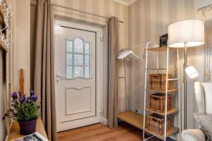 a room with a white door and a shelf with baskets at Villa Gute Zeit - Cosy Apartment in Nortorf