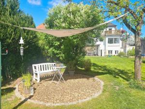 a hammock hanging from a tree in a yard at Villa Gute Zeit - Cosy Apartment in Nortorf