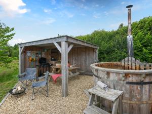 a wooden shed with a grill and a table and chairs at The Sheep Pod - Uk50074 in Welshpool