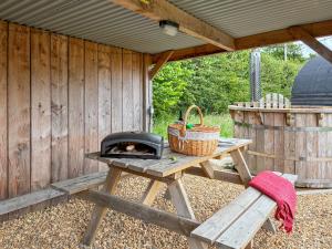 a picnic table with a grill and a picnic bench at The Sheep Pod - Uk50074 in Welshpool