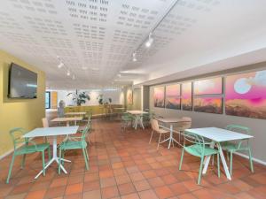 a dining room with tables and chairs and a tv at B&B HOTEL Alba in Alba +24 photos